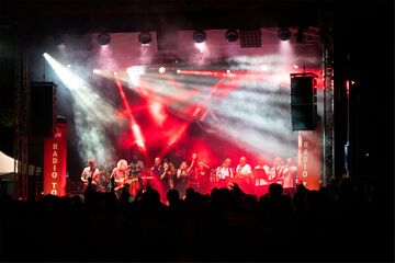 Liveband auf Bühne vor Publikum im Scheinwerferlicht